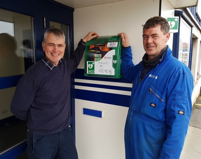 Neil Fraser and Gary Leask show the location of the defibrillator outside the DITT office and shop at Holmsgarth Road, Lerwick.
